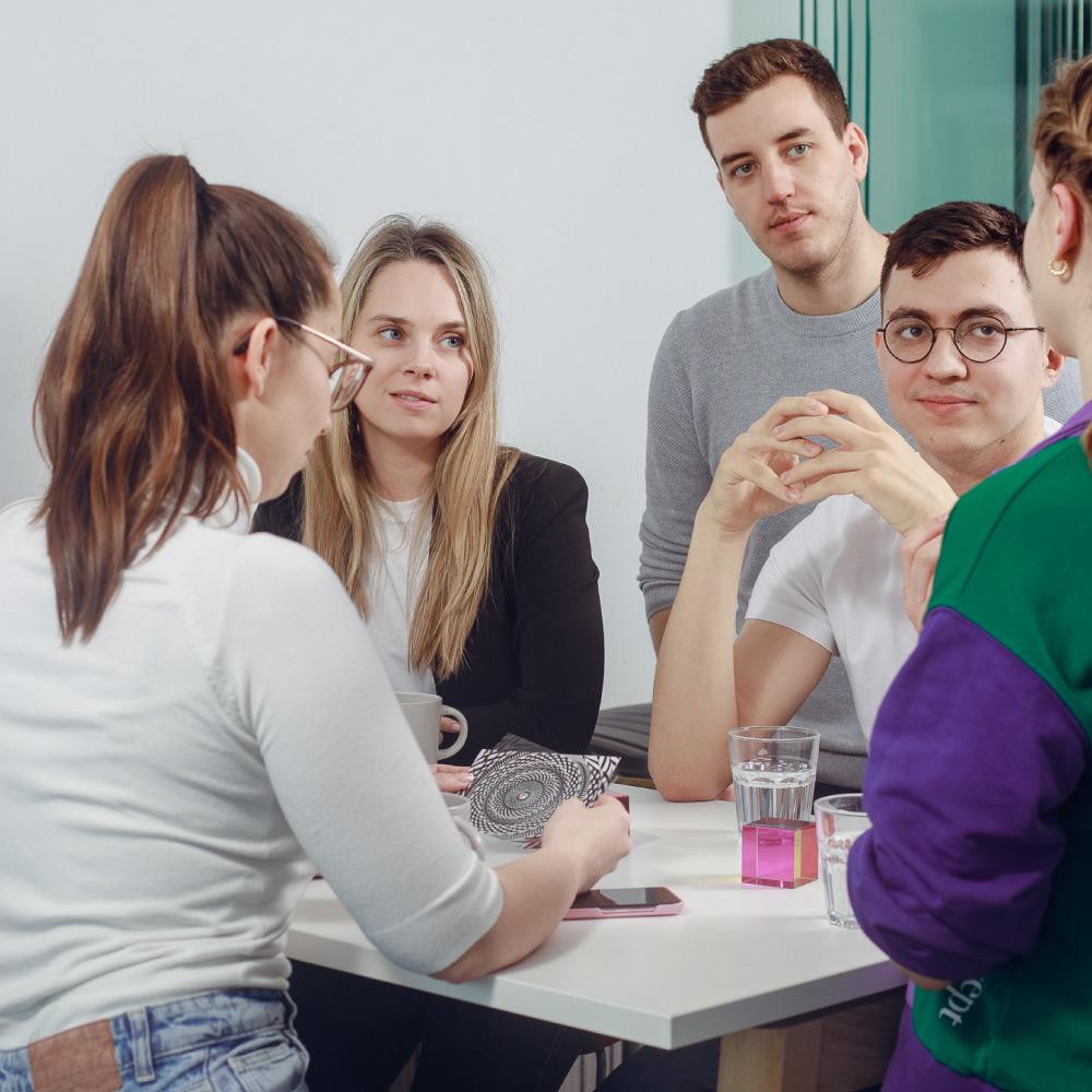 Team members gathered around a table collaborating, with discussion materials and notes during a teamwork session.